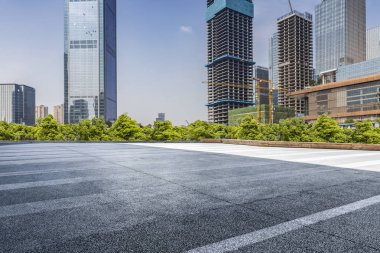 Panoramik siluet ve boş yolu, boş beton zemini olan modern iş binaları.