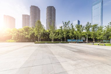 Panoramik siluet ve boş yolu, boş beton zemini olan modern iş binaları.