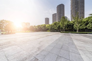 Panoramik siluet ve boş yolu, boş beton zemini olan modern iş binaları.