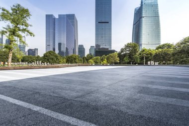 Panoramik siluet ve boş yolu, boş beton zemini olan modern iş binaları.