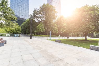 Panoramik siluet ve boş yolu, boş beton zemini olan modern iş binaları.