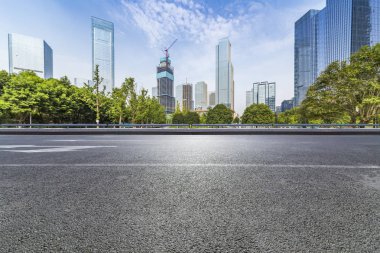 Panoramik siluet ve boş yolu, boş beton zemini olan modern iş binaları.