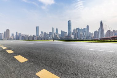 Panoramik siluet ve boş yolu, boş beton zemini olan modern iş binaları.
