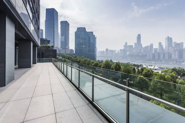 Panoramik siluet ve boş yolu, boş beton zemini olan modern iş binaları.