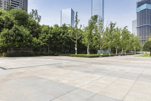 Panoramik siluet ve boş yolu, boş beton zemini olan modern iş binaları.