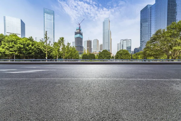 Panoramik siluet ve boş yolu, boş beton zemini olan modern iş binaları.