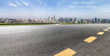 Panoramik siluet ve boş yolu, boş beton zemini olan modern iş binaları.