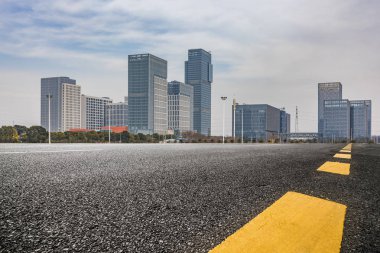 Panoramik siluet ve boş yolu, boş beton zemini olan modern iş binaları.