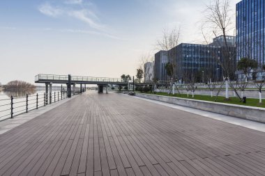 Panoramik siluet ve boş yolu, boş beton zemini olan modern iş binaları.