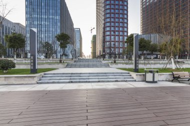 Panoramik siluet ve boş yolu, boş beton zemini olan modern iş binaları.