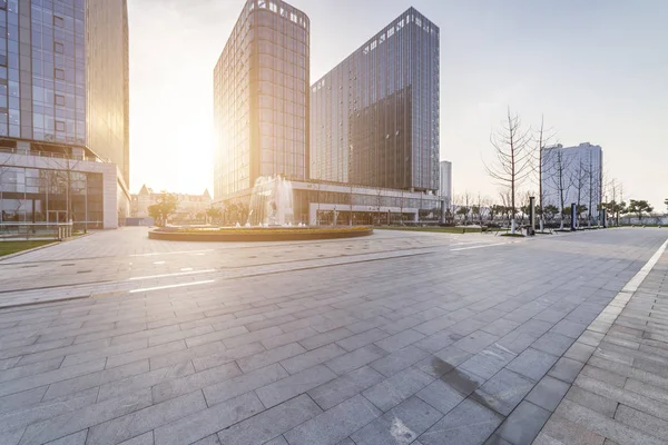 Panoramik siluet ve boş yolu, boş beton zemini olan modern iş binaları.