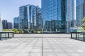 Panoramatické panorama a moderní kancelářské budovy s prázdnou silnicí, prázdné betonové čtvercové podlahy