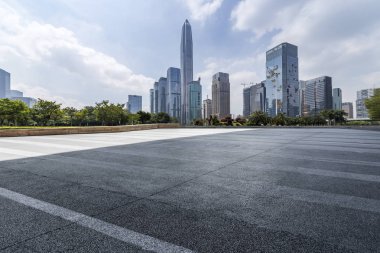 Panoramik siluet ve boş yolu, boş beton zemini olan modern iş binaları.