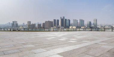 Panoramik siluet ve boş yolu, boş beton zemini olan modern iş binaları.