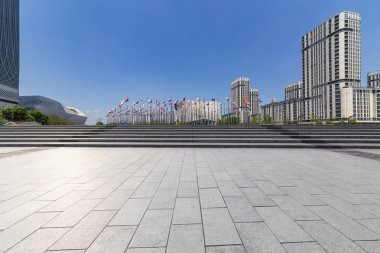 Panoramik siluet ve boş yolu, boş beton zemini olan modern iş binaları.