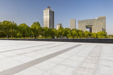 Panoramik siluet ve boş yolu, boş beton zemini olan modern iş binaları.