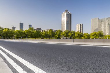 Panoramik siluet ve boş yolu, boş beton zemini olan modern iş binaları.