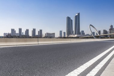Panoramik siluet ve boş yolu, boş beton zemini olan modern iş binaları.