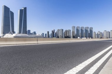 Panoramik siluet ve boş yolu, boş beton zemini olan modern iş binaları.