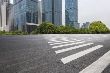 Panoramik siluet ve boş yolu, boş beton zemini olan modern iş binaları.