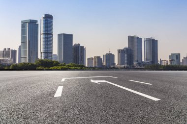 Panoramik siluet ve boş yolu, boş beton zemini olan modern iş binaları.