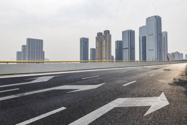 Panoramik siluet ve boş yolu, boş beton zemini olan modern iş binaları.