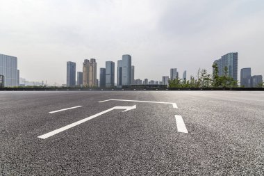 Panoramik siluet ve boş yolu, boş beton zemini olan modern iş binaları.