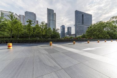 Panoramik siluet ve boş yolu, boş beton zemini olan modern iş binaları.