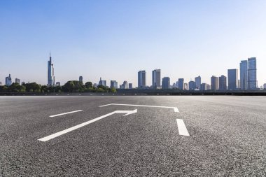 Panoramik siluet ve boş yolu, boş beton zemini olan modern iş binaları.