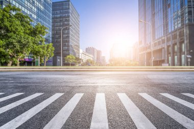 Panoramik siluet ve boş yolu, boş beton zemini olan modern iş binaları.
