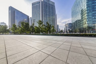 Panoramik siluet ve boş yolu, boş beton zemini olan modern iş binaları.