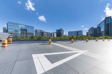 Panoramik siluet ve boş yolu, boş beton zemini olan modern iş binaları.