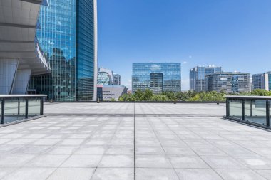 Panoramik siluet ve boş yolu, boş beton zemini olan modern iş binaları.