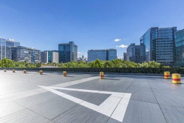 Panoramik siluet ve boş yolu, boş beton zemini olan modern iş binaları.