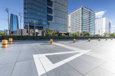 Panoramik siluet ve boş yolu, boş beton zemini olan modern iş binaları.