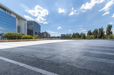 Panoramik siluet ve boş yolu, boş beton zemini olan modern iş binaları.