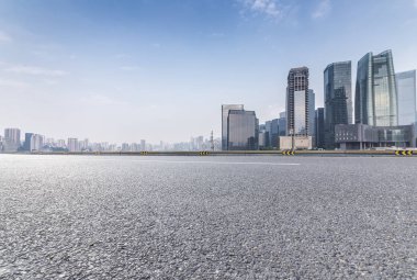 Panoramik siluet ve boş yolu, boş beton zemini olan modern iş binaları.