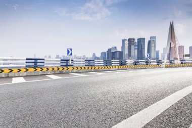 Panoramik siluet ve boş yolu, boş beton zemini olan modern iş binaları.