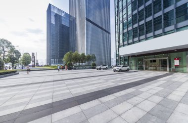 Panoramik siluet ve boş yolu, boş beton zemini olan modern iş binaları.