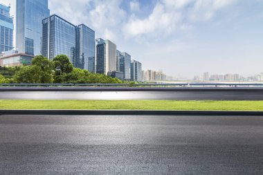 Panoramik siluet ve boş yolu, boş beton zemini olan modern iş binaları.