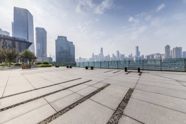 Panoramik siluet ve boş yolu, boş beton zemini olan modern iş binaları.