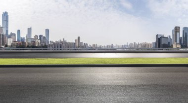 Panoramik siluet ve boş yolu, boş beton zemini olan modern iş binaları.