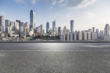 Panoramik siluet ve boş yolu, boş beton zemini olan modern iş binaları.