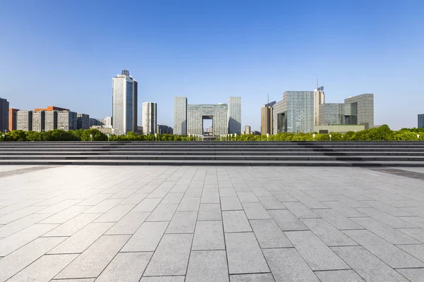 Panoramik siluet ve boş yolu, boş beton zemini olan modern iş binaları.