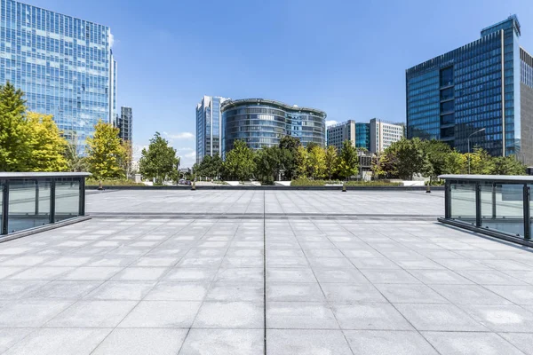 Panoramik siluet ve boş yolu, boş beton zemini olan modern iş binaları.