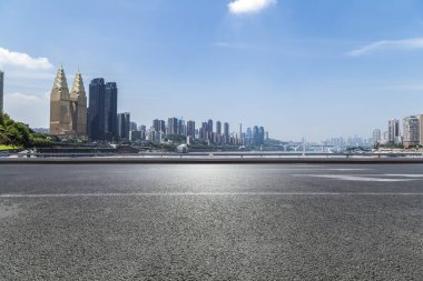 Panoramik siluet ve boş yolu, boş beton zemini olan modern iş binaları.