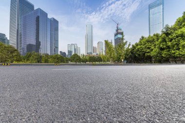 Panoramik siluet ve boş yolu, boş beton zemini olan modern iş binaları.