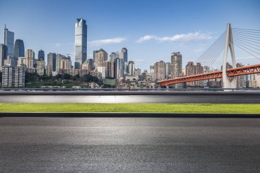 Panoramik siluet ve boş yolu, boş beton zemini olan modern iş binaları.