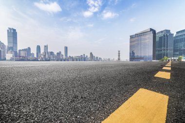 Panoramik siluet ve boş yolu, boş beton zemini olan modern iş binaları.