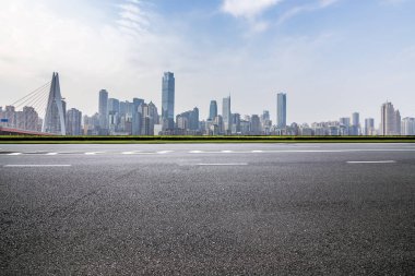 Panoramik siluet ve boş yolu, boş beton zemini olan modern iş binaları.